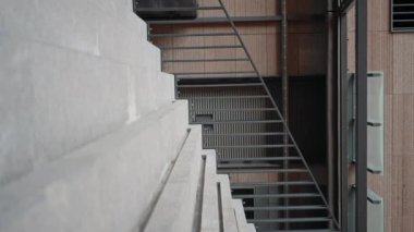 Acele et genç işadamı merdivenlerden çıkıp işe gidiyor. Ofis resmi takım elbiseli işçi şehir dışında yürüyor. Yavaş çekim 4K.