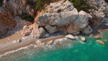 Antalya, Kas, Türkiye yakınlarındaki Turkuaz Sahili 'nde kırılan dalgalar ve gizli sahil şeridi boyunca kuş bakışı görüntüler. 4k, 25Fps 'te.