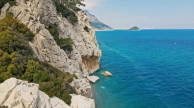 Antalya, Kas, Türkiye yakınlarındaki Turkuaz Sahili 'nde kırılan dalgalar ve gizli sahil şeridi boyunca kuş bakışı görüntüler. 4k, 25Fps 'te.