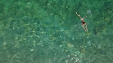 Bikini mayo giymiş genç bir kadının mercan resifinde denizde rahatlamasını gösteren hava manzarası. Mutlu ada yaşam tarzı. Cennet 'te tatil. Okyanus rahatlaması, Tayland 'a seyahat