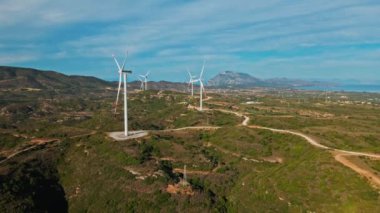 Türkiye 'nin Datca kentindeki sinematik yeşil tepelerde büyük sürdürülebilir enerji üretim çiftliğine rüzgar türbinleri ve destansı hava manzarası ile elektrik üretimi