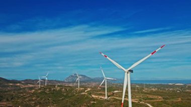 Rüzgarın gücüyle dönen ve yenilenebilir enerji üreten rüzgar değirmenlerinin havadan yakın çekim görüntüleri. Gezegene giden yeşil ekolojik yol.