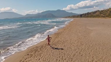 Türkiye 'deki Iztuzu Kaplumbağa plajında koşan çekici fitness kadını..