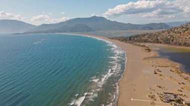 Güneş doğarken tropikal beyaz kum plajı üzerinde uçan hava manzarası, Iztuzu Kaplumbağa Sahili, Türkiye