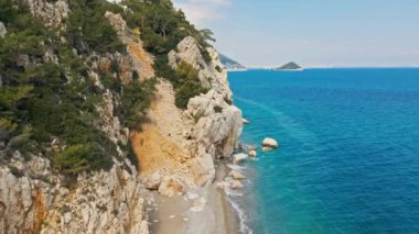 Antalya, Kas, Türkiye yakınlarındaki Turkuaz Sahili 'nde kırılan dalgalar ve gizli sahil şeridi boyunca kuş bakışı görüntüler. 4k, 25Fps 'te.