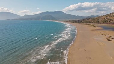 Güneş doğarken tropikal beyaz kum plajı üzerinde uçan hava manzarası, Iztuzu Kaplumbağa Sahili, Türkiye