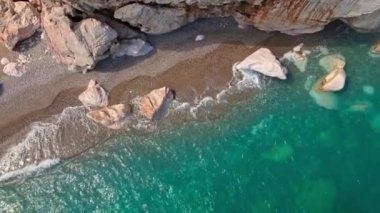 Antalya, Kas, Türkiye yakınlarındaki Turkuaz Sahili 'nde kırılan dalgalar ve gizli sahil şeridi boyunca kuş bakışı görüntüler. 4k, 25Fps 'te.