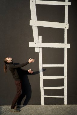 Siyahlı adam, kolları yukarı doğru uzanan resimli merdivenlere uzanmış bir şekilde yan ayakta duruyor. Merdiven sosyal hiyerarşinin görsel bir temsili. Sosyal Merdiven Yükseltiliyor