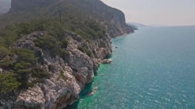 Antalya, Kas, Türkiye yakınlarındaki Turkuaz Sahili 'nde kırılan dalgalar ve gizli sahil şeridi boyunca kuş bakışı görüntüler. 4k, 25Fps 'te.