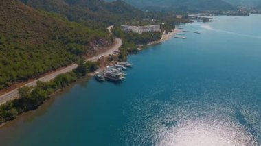 Türkiye 'de güneşli bir günde İHA' nın yüksek noktasından Antalya Körfezi 'ne ait hava görüntüleri. Kuşlardan inanılmaz bir şehir manzarası. Güzel kasaba ve deniz yamaçları üzerinde uçuyorlar.
