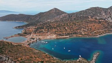 Yukarıdan bakıldığında, şeffaf ve turkuaz deniz manzaralı birkaç tekne ve yatla. Akdeniz kıyıları, Knidos Antik kenti, Datca, Türkiye. Yaz tatili ve deniz kenarına seyahat