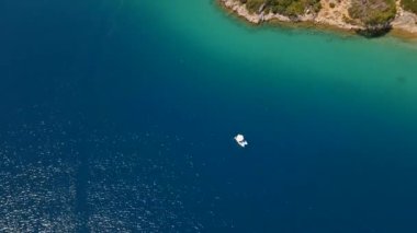 Fethiye 'deki Oludeniz yarımadasının muhteşem hava manzarası, mavi lagün, kumlu sahil üzerinde İHA uçuşu, turkuaz deniz, güneş yatakları ve şemsiyeli sahil beldesi, sıcak yaz günü..