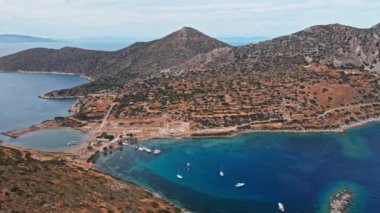 Yukarıdan bakıldığında, şeffaf ve turkuaz deniz manzaralı birkaç tekne ve yatla. Akdeniz kıyıları, Knidos Antik kenti, Datca, Türkiye. Yaz tatili ve deniz kenarına seyahat