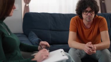Sorunlu genç adam, oturumdaki psikoterapist sorununu anlatırken konsantre olmaya çalışıyor