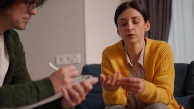 Depresyondaki kadın terapi seansı yapıyor, konuşuyor ve terapist de notlar, zihinsel bozukluklar ve psikoloji konsepti yazıyor.
