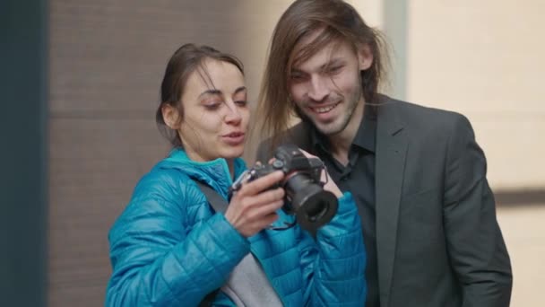 迷人的女摄影师在城市街道上为年轻英俊的商人拍照 妇女向客户展示她在数码相机展示方面的研究成果并进行讨论 — 图库视频影像