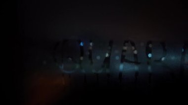 Karantina kelimesi gece karanlığında sisli bardağın üzerine parmak ile yazılmış. Su damlaları bardaktan aşağı akar..