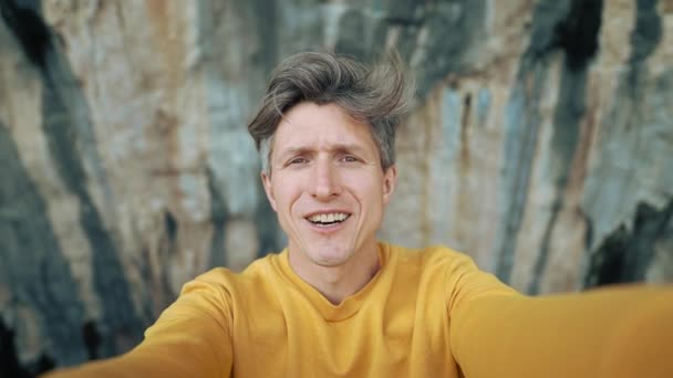 Feliz Sorrindo Homem Leva Vídeo Selfie Contra Fundo Belas Rochas — Vídeo de Stock