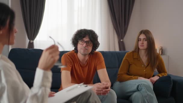 年轻夫妇坐在心理学家面前的沙发上 讨论和解决他们的关系问题 专业人员帮助克服人际关系方面的挑战 — 图库视频影像