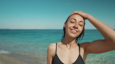 Beautiful american girl enjoying weekend at seashore, standing with open arms and feeling happiness