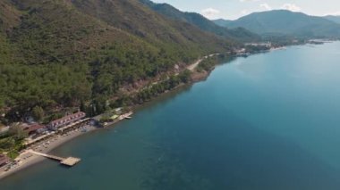Türkiye 'de güneşli bir günde İHA' nın yüksek noktasından Antalya Körfezi 'ne ait hava görüntüleri. Kuşlardan inanılmaz bir şehir manzarası. Güzel kasaba ve deniz yamaçları üzerinde uçuyorlar.