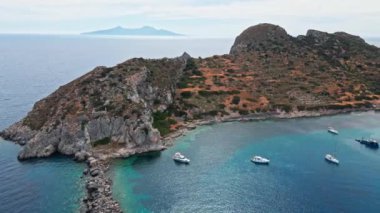 Yukarıdan bakıldığında, şeffaf ve turkuaz deniz manzaralı birkaç tekne ve yatla. Akdeniz kıyıları, Knidos Antik kenti, Datca, Türkiye. Yaz tatili ve deniz kenarına seyahat