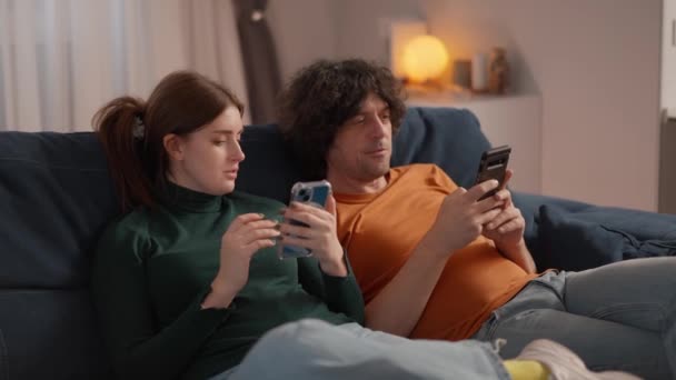 Cuplu Tânăr Culcat Canapea Acasă După Muncă Ambii Uită Smartphone — Videoclip de stoc