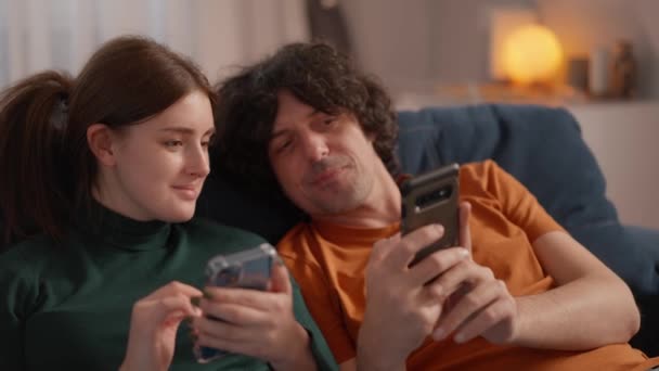 Mladý Pár Ležící Doma Gauči Práci Oba Hledající Svých Smartphonech — Stock video