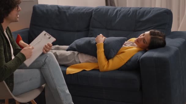 Zdenerwowana Kobieta Żółtym Swetrze Leżąca Kanapie Rozmawiająca Psychologiem Podczas Sesji — Wideo stockowe