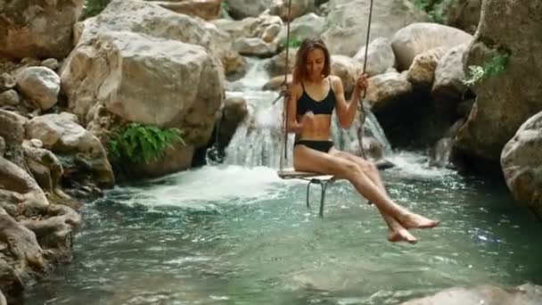 Szczęśliwa Kobieta Bikini Huśtawce Lesie Deszczowym Brzegu Rzeki Widok Przodu — Wideo stockowe