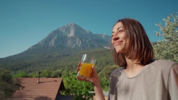야외에서 아침에 즐거운 부부는 산에서 야영을 즐기고 오렌지 주스를 마십니다 — 비디오