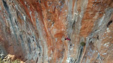 Gökyüzü manzaralı güzel atletik kadın kaya tırmanışçısı Türkiye 'nin manzaralı kireçtaşı duvarında zorlu bir yola tırmanıyor. Geyikbayiri 'de spor tırmanışı.