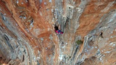 Gökyüzü manzaralı güzel atletik kadın kaya tırmanışçısı Türkiye 'de manzaralı kireçtaşı duvarda zorlu bir yola tırmanıyor. Geyikbayiri 'de spor tırmanışı.