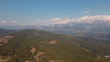 Yeşil çam ağaçları, kar kaplı dağları ve güneşli bulutlu gökyüzü olan güzel manzaralı bir dağ sırtı. Türkiye 'de seyahat, Tazi kanyonu bölgesinde. Sinematik İHA, 4 km yavaş çekim çekiyor.
