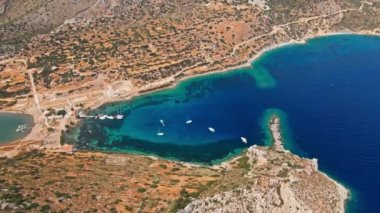 Yukarıdan bakıldığında, şeffaf ve turkuaz deniz manzaralı birkaç tekne ve yatla. Akdeniz kıyıları, Knidos Antik kenti, Datca, Türkiye. Yaz tatili ve deniz kenarına seyahat