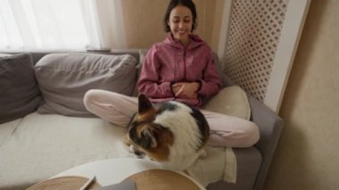 POV, evinde güzel gülümseyen bir kızla kanepede oturan komik Galli Corgi Dog 'a ilk bakışı. Bataklık havlıyor, yemek istiyor ve pati yapıyor. Evcil hayvanlarla ve ev hayatıyla arkadaşlık. komik hayvanlar.