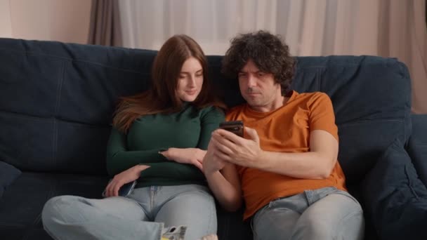 Fiatal Pár Otthon Fekszik Kanapén Munka Után Mindketten Okostelefonjaikat Nézik — Stock videók