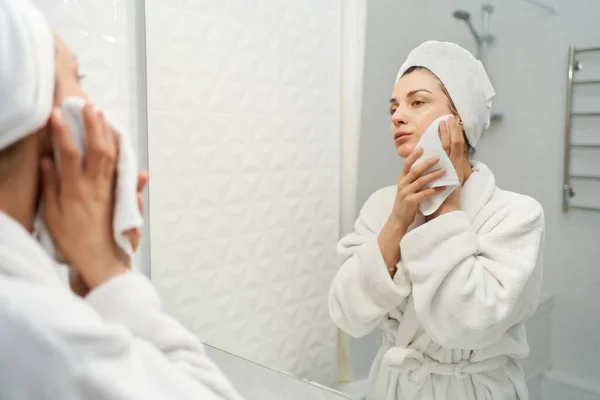 Mulher Graciosa Roupão Banho Usando Toalha Cabeça Fica Frente Espelho — Fotografia de Stock