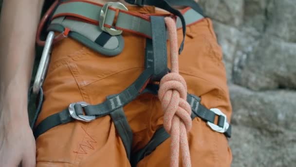 女攀岩运动员准备攀岩 女登山者检查悬崖峭壁下的绳结准备爬山 — 图库视频影像