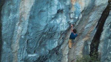 rock climber climbs the rock. a strong man overcomes a difficult route. relaxation and freedom in nature.