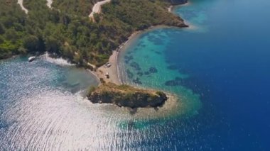 Türkiye 'de Akdeniz kıyısında arabaları ve kamyonetleriyle vahşi kamp yapmak için güzel bir hava manzarası. Minibüs turizmi yaz tatili. Ada sahilinde tenha bir sahil.