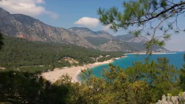 İnsansız hava aracı, yeşil ağaç dallarından Akdeniz kıyısındaki Antalya, Türkiye 'deki güzel deniz sahillerine uçuyor. Hava manzarası Dağ sırtının altında inanılmaz deniz manzarası