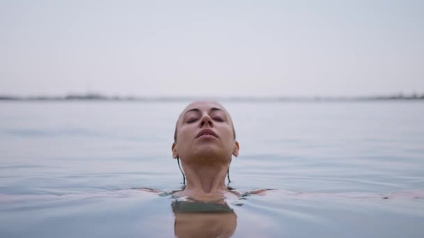 美丽的女人从湖面上来 水从她的脸上掉下来 动作缓慢 — 图库视频影像