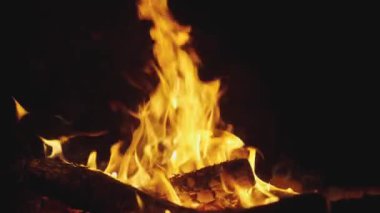 Gece yakın planda şenlik ateşi yakmak. seyahat macerası konsepti. Gece ateşinin kıvılcımları yakın planda. Gece çayırında bir şenlik ateşinin yakın çekimi. Yaşam tarzında sıcak kömür, ateşte.