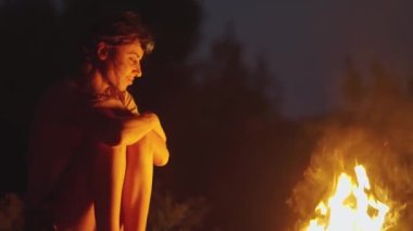 Yürüyüş yapan kadın yaz tatilinde vahşi doğa ağaçlarının dışında ateş yakıyor. Rahatlatıcı sessizlik kamp turuncu kırmızı alevler sıcak kamp ateşi manzarası