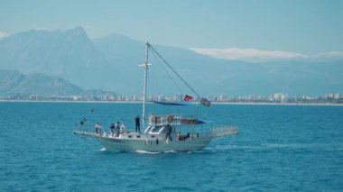 Yelkenli yat, turkuaz deniz suyuyla körfezde yüzüyor. Antalya limanında yelkenli yat, Türkiye. Denizi ve dağları olan güzel bir yer.