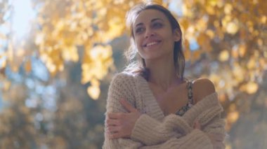 Sonbahar kırsalında yürürken, ağır çekimde çekilmiş güzel bir kadının kafa ve omuz portresi. Sonbahar güzelliği