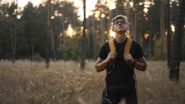 슬로우 남자는 숲에서 흔적에 노란색 안경에 잔디와 나무를 올라가는 하이커 — 비디오