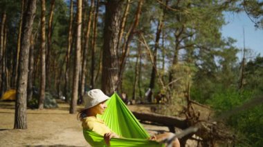 Ormandaki dağ gölü kıyısında hamakta sallanan mutlu, rahat bir kadın. Seyahat, yaz tatili, açık havada seyahat, boş zaman. Panama 'da gezen dişi yeşil hamakta dinleniyor.