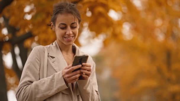 Sonbahar Parkında Telefonu Olan Bir Kadın Altın Sonbahar Parkındaki Zarif — Stok video